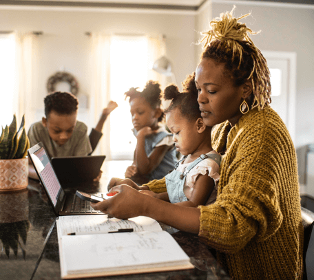 Woman with family multi-tasking at table