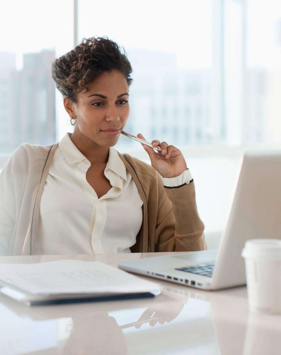 Lady looking at laptop with documents - Desktop